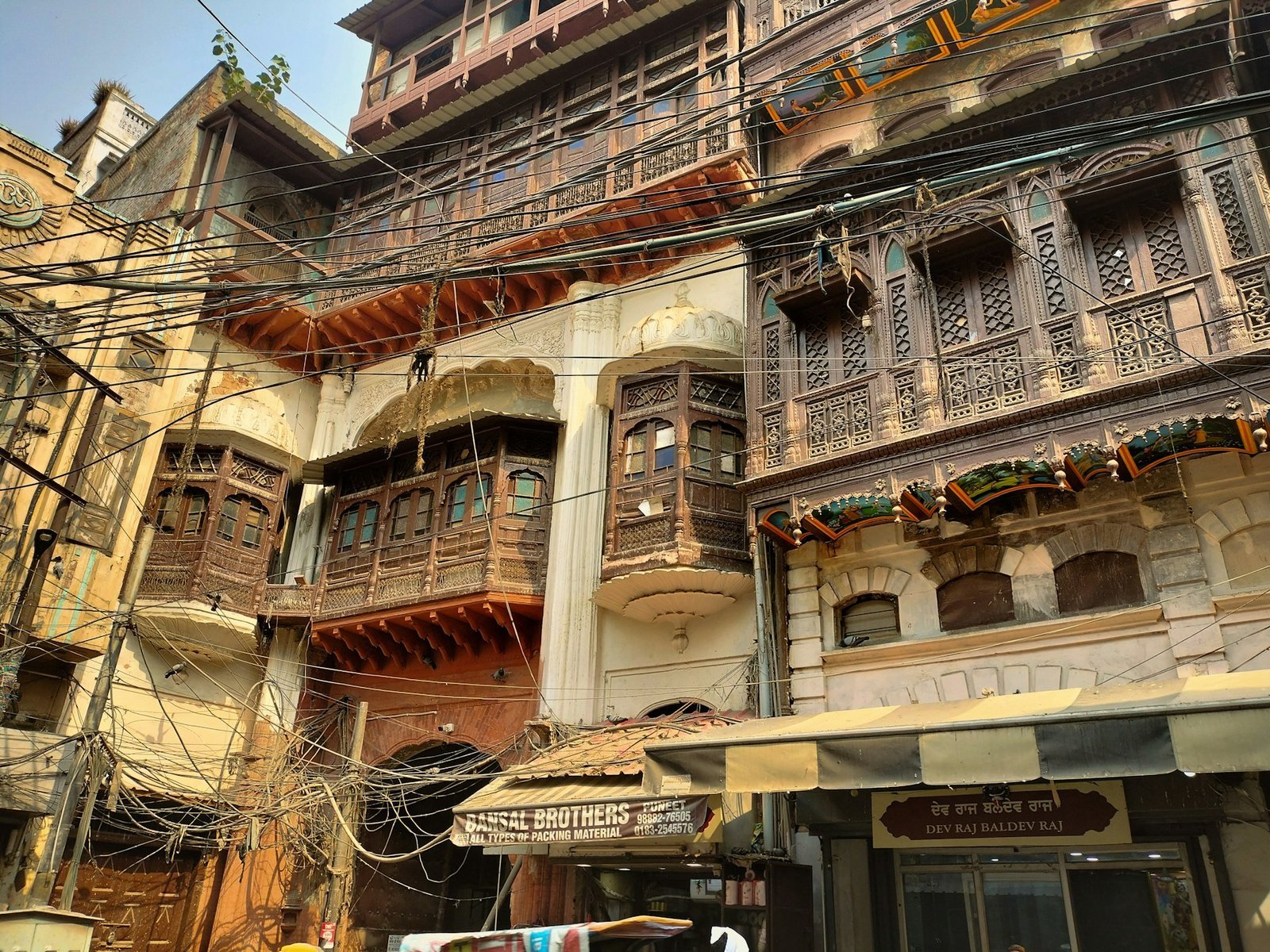 Ornate carved wooden balconies on a heritage building in Amritsar's old city, the kind of architecture lining the lanes near Hall Bazaar