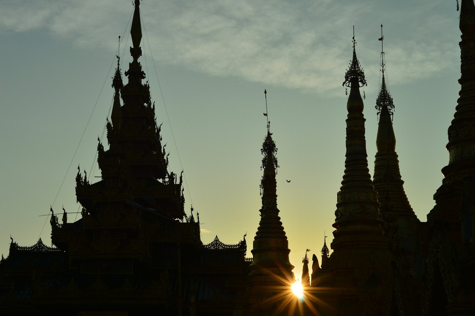 Silhouette of Shwedagon Pagoda's golden spires against the sunset sky in Yangon